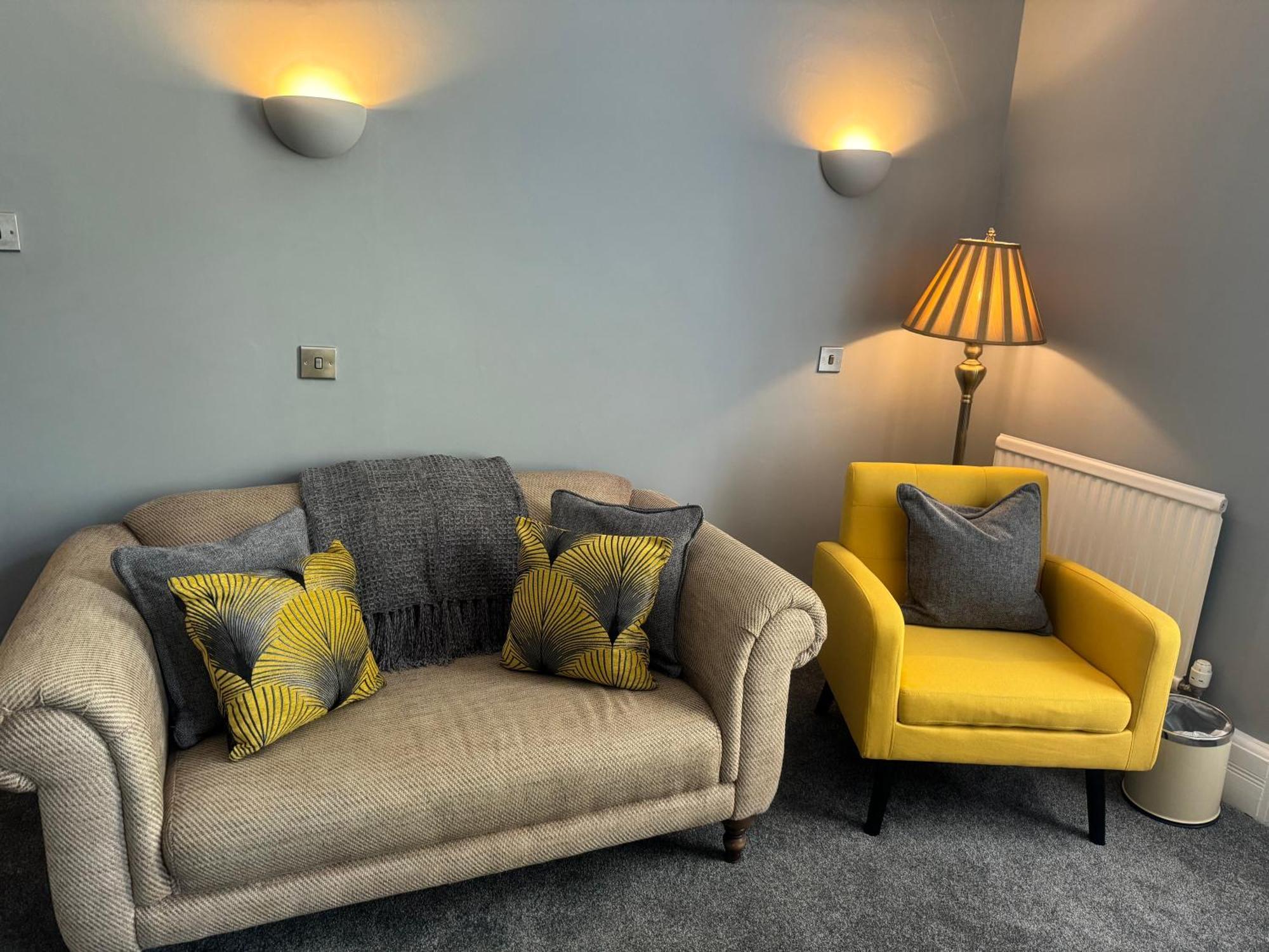 The Red Lion Hotel Cromer Esterno foto A living room with a sofa and a chair
